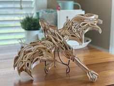 a wooden sculpture of a dog made out of paper on top of a wood table