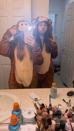 a woman taking a selfie in front of a mirror with monkeys on her head