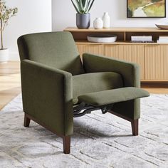 a green chair sitting on top of a white rug