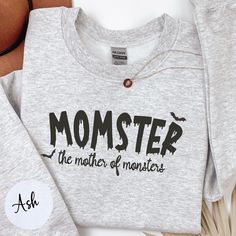 Momster Sweatshirt | Halloween Mom Shirt | Women Halloween Shirt | Halloween Gifts | Fall Shirt | Funny Mom Shirt | Halloween Gift for Mom Unleash your inner "Momster" with this playful and spooky shirt! Perfect for busy moms who juggle it all with a bit of Halloween spirit, this shirt is a must-have for the season. Made from super-soft fabric, it's great for everything from school drop-offs to haunted house visits. The fun and cheeky design pairs perfectly with jeans, leggings, or joggers, making it a versatile addition to your fall wardrobe. Don't miss out--grab your "Momster" shirt and show off your monster mom style! PRODUCTION & SHIPPING - Production: 2-5 days, custom designs may require up to 2 additional days - Free Standard Shipping  - Items are shipped within 3-5 days after produc Halloween Cotton Pre-shrunk Sweatshirt, Halloween Themed Cotton Tops, Themed Cotton Tops For Halloween, Cotton Halloween Themed Tops, Customizable Cotton Novelty Tops, Halloween Themed Streetwear Tops, Halloween Themed Crew Neck Tops, Halloween Themed Tops With Crew Neck, Themed Long Sleeve Letter Print T-shirt