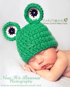 a newborn baby wearing a green crocheted hat with ears and eyes on it's head