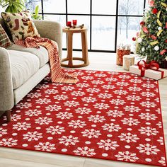 a living room decorated for christmas with red and white rugs on the floor, holiday tree in background