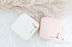 two small pink and white cases sitting next to each other on a fur covered surface