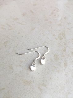 Delicate and Feminine Heart Earrings! Made with an unwon pair of 925 sterling silver earring hooks (includes clear earring backing) Heart is 925 sterling silver Length .5 inch Width .25 inch Heart Charm Drop Earrings For Mother's Day, Nickel-free Sterling Silver Earrings For Mother's Day, Sterling Silver Earrings With Ear Wire For Mother's Day, Minimalist Heart Drop Earrings As Gift, Teardrop Heart Earrings In Sterling Silver, Minimalist Hypoallergenic Earrings For Mother's Day, Hypoallergenic Heart Earrings As Gift For Her, Mother's Day Heart Drop Earrings, Dangle Heart Charm Earrings For Gifts