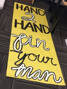 a yellow sign that says hand & hand pin your man on it with black lettering