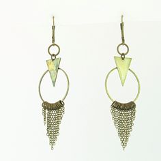 These fun geometric charm earrings come in a subtle antique brass finish. Each earring has a cascade of dainty chains hanging from a hoop in a chainmail reminiscent pattern. These bold and lively earrings are sure to make an impression. With a matching necklace available, this would make a fabulous gift set! -Geometric triangle and hoop charm -hanging chain accents -Antique brass finish -Leverback earring closure Bohemian Geometric Metal Jewelry, Bronze Metal Dangle Chandelier Earrings, Minimalist Metal Dangle Chandelier Earrings, Nickel Free Triangle Metal Earrings, Geometric Nickel-free Metal Earrings, Nickel-free Geometric Metal Earrings, Nickel-free Metal Triangle Earrings, Nickel-free Triangle Bohemian Jewelry, Handmade Triangle Brass Jewelry