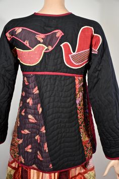 "This is an 70s/80s Jeanne Marc quilted patchwork jacket with an old Jeanne Marc label. This jacket has a scoop neck, snaps down the front, the upper chest and arms are black quilted, below the bust the jacket has patchwork feather and floral motifs in fall like colors.There ate two hoodie style patch pocket at the front waist. The jacket is edged in a maroon giving a geometric quality to the coat. The back of the coat has three doves on the upper back that are appliqued in different playful fab Fall Long Sleeve Outerwear With Collage Stitching, Bohemian Winter Outerwear With Patches, Spring Vintage Quilted Jacket With Patchwork, Bohemian Long Sleeve Outerwear With Patches, Vintage Quilted Patchwork Jacket, Quilted Bohemian Long Sleeve Outerwear, Bohemian Quilted Spring Outerwear, Applique Birds, Patchwork Quilt Jacket