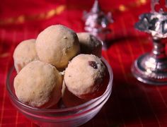 some food is in a glass bowl on a red tablecloth with silver candlesticks