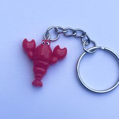 a red keychain with a small plastic lobster on it's front end