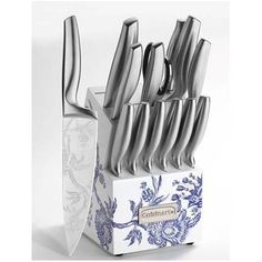 a set of knives in a box with blue and white flowers on the front side