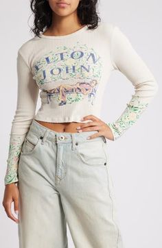 A '70s-era Elton John reclines amidst English garden blooms on this long-sleeve pointelle T-shirt. 17 1/2" length (size Medium) Crewneck Long sleeves 100% cotton Dry clean or hand wash, dry flat Made in the USA Trendy Stretch Long Sleeve Top For Spring, Spring Graphic Print Stretch Tops, Graphic Print Stretch Top For Spring, Stretch Graphic Print Tops For Spring, Trendy Long Sleeve Spring Tops, Fitted Casual Long Sleeve Top For Spring, Retro Long Sleeve Spring Tops, Retro Long Sleeve Tops For Spring, Trendy Spring Long Sleeve Crew Neck Top