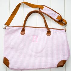 "Ready for a weekend getaway? Whether its a short trip to the beach, mountains, or somewhere in between, this seersucker weekender is the perfect bag to take! Stylish seersucker with faux leather accents and an embroidered name or monogram to top it off. Great for teenager girls all the way to college grads! Weekender measures 24x14x9, perfect for a weekend getaway. Removable shoulder strap, inside zipper pocket, and 2 additional small open pockets. Embroidered with name, monogram, or design. Pl Personalized Weekender Bag, Pink Shoulder Weekender Bag, Everyday Pink Weekender Bag With Double Handle, Classic Monogram Canvas Duffle Bag, Pink Monogram Canvas Shoulder Bag For Travel, Sac Week End, Hospital Bag, Travel Duffel, Duffel Bag Travel