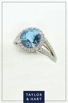 a blue stone surrounded by white diamonds in a ring with the words taylor and hart on it