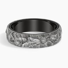 a black and white wedding band with seashells inlaying it's center