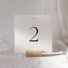 a white card with the number two on it and a rubber stamp in front of it