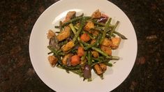 a white plate topped with green beans and croutons