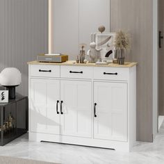 a white cabinet with two doors and drawers in a room next to a mirror on the wall