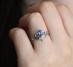 a woman's hand with a ring on it and a blue stone in the middle