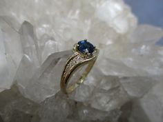 This 14K Gold Ring is set with a beautiful gem grade Sapphire and accented with Diamonds. The Oval Cut Sapphire has great blue color. Not too dark and not too light. It measures 5.5 mm by 4.5 mm and weighs .66 carat. It is a clean, well cut natural stone. There are 8 accenting Diamonds, 4 on each side. The accent Diamonds weigh .05 carat total weight. The ring is about 5/16 inch wide on top and tapers to a narrow band in the back. Low profile settings make this a very wearable ring. It is made i Anniversary Sapphire Ring With Side Stones In Round Cut, Anniversary Sapphire Ring With Diamond Side Stones, Anniversary Sapphire Ring With Round Cut Side Stones, Round Cut Sapphire Ring With Side Stones For Anniversary, Anniversary Sapphire Ring With Side Stones, Anniversary Round Cut Sapphire Ring With Side Stones, Anniversary Sapphire Jewelry With Side Stones, Elegant Sapphire Ring With Diamond Side Stones, Yellow Gold Sapphire Ring With Accent Stones For Wedding