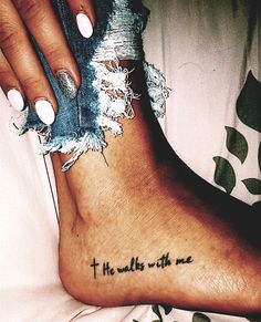 a woman's foot with the words, he walks with me tattooed on it