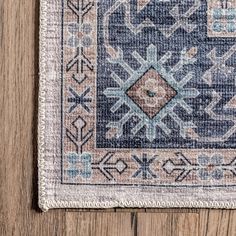 a blue and beige rug on top of a wooden floor