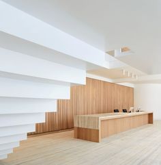 an empty white room with wooden flooring and stairs leading up to the second floor