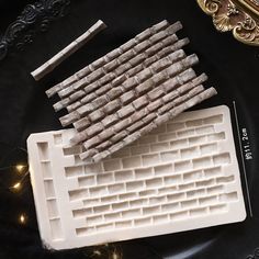 several pieces of white plastic sitting on top of a black plate next to a mirror