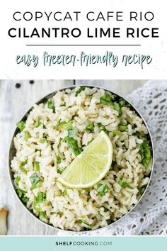 a white bowl filled with rice, lime and cilantro on top of a wooden table