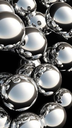 an array of shiny glass balls on a black background, with reflections in the middle