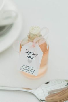 a jar of jam sitting on top of a white table next to a silver spoon