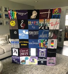 a quilt made out of many different types of t - shirts on display in a living room