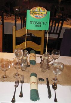 the table is set with silverware and wine glasses