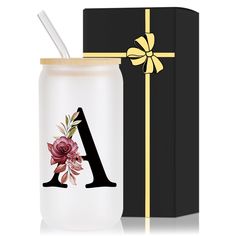 a glass jar with a straw in it next to a gift box and the letter a