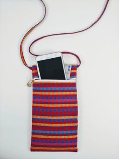 a cell phone in a pouch on a white surface with a red and blue checkered pattern