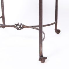 an iron table with a marble top and metal legs, on a plain white background