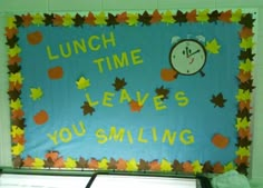 a bulletin board that says lunch time leaves you smiling and an alarm clock on it