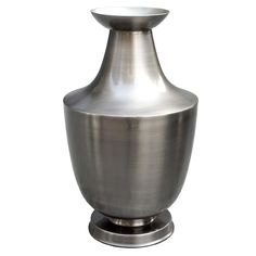 a large metal vase sitting on top of a table