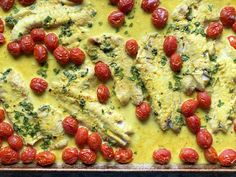 a pan filled with chicken and tomatoes covered in sauce