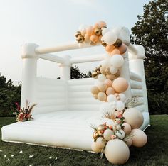 an inflatable couch with balloons and flowers on the back is set up for a party