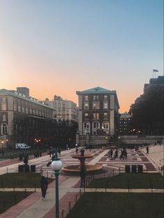 people are walking around in the park at sunset