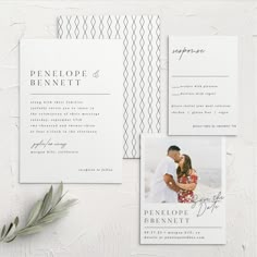 the wedding stationery is laid out on a white surface with greenery and an olive branch