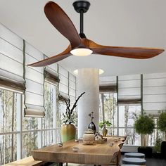 a ceiling fan is hanging in the middle of a dining room table with four stools