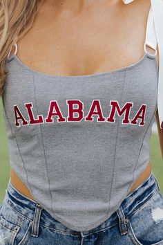 This Alabama top is expertly designed and perfect for gameday! The Alabama Satin Bow Top features self-tie satin straps and game day embroidery. The boning at the front provides structure and the cropped length adds a modern touch. Made with a blend of cotton, nylon, and spandex, with a polyester lining for comfort! For the perfect tailgate outfit, simply style it with your favorite denim wear and sneakers! Sporty Crop Top For College In Spring, Collegiate Style Fitted Tops For Spring, Fitted Tops For Game Day In Spring, Collegiate Sleeveless Fitted Top, Collegiate Tops For Spring Sports Events, Collegiate Tops For Sports Events In Spring, Collegiate Fitted Sleeveless Top, Fitted Sleeveless Top For Game Day, Collegiate Style Tops For Spring Sports Events