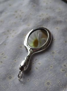 a close up of a magnifying glass on a table cloth with an object in the background