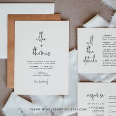 the wedding stationery is laid out on top of torn up paper and placed in front of each other