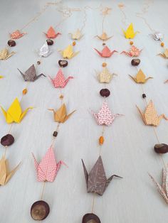 several origami cranes are arranged on a table with buttons and string attached to them