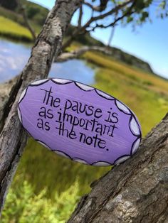 a purple sign that says the pause is as important as the note on a tree