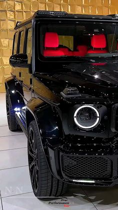 the front end of a black mercedes g - class suv on display at an auto show