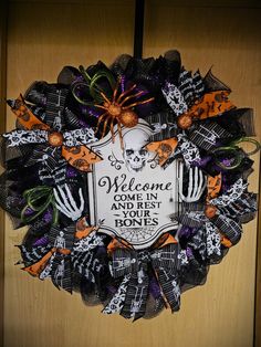 a halloween wreath with the words welcome come in and eat bones