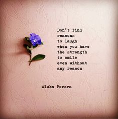 a blue flower sitting on top of a pink wall next to a quote that says don't find reasons to laugh when you have the strength to smile even without any reason